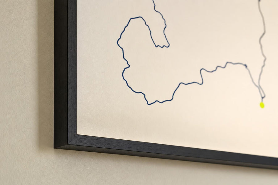 Detalle en escorzo del marco de un cuadro colgado en la pared, con el trazado desenfocado al fondo.