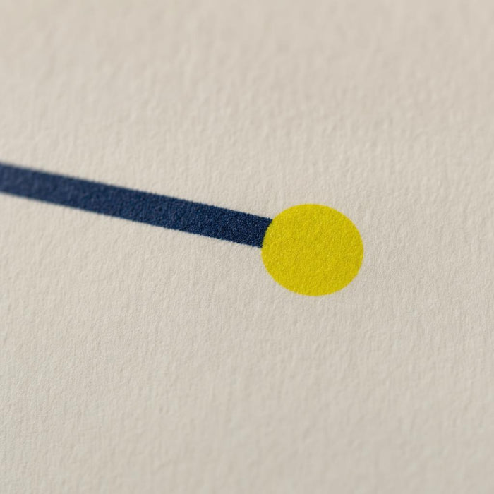 Detalle macro del punto amarillo de meta impreso al final del trazado, sobre papel hueso.