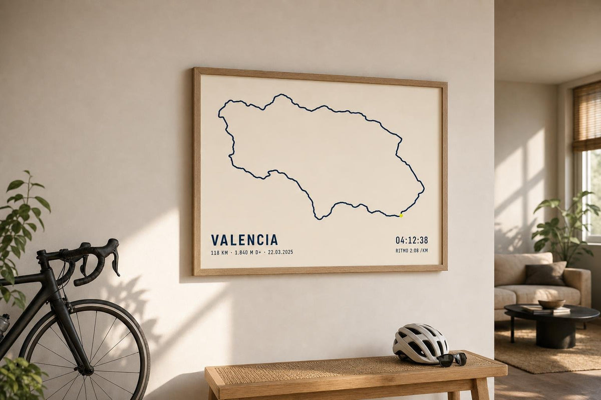Cuadro con una ruta ciclista en Valencia colgado en la pared de un salón, junto a una bicicleta de carretera y un casco.
