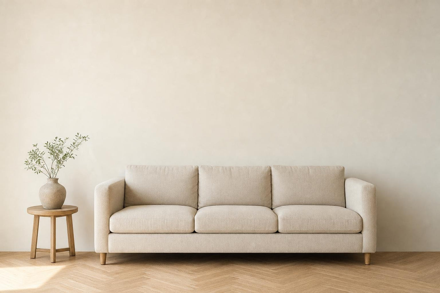 Salón con un sofá de lino de 190 cm y la pared vacía encima.